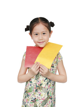 Portrait of happy little Asian girl wearing cheongsam smiling and holding gold and red envelope. Happy Chinese New Year.