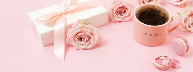 Valentine's day, birthday background banner. Pink cup of coffee, pink roses and pink macaroons on pink background. Copy space