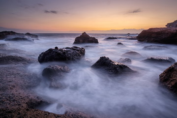 Sea wave on long exposure during sunset on the seashore