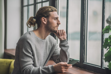Young bearded handsome man in grey feeling thoughtful - Powered by Adobe