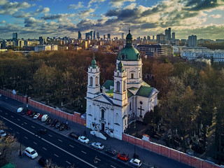 Fototapeta Beautiful panoramic aerial drone view to the Сenter of modern Warsaw city with silhouettes of skyscrapers and Church Karol Boromeusz (at the Powazki Cemetery) in amazing winter January sunset, Poland obraz