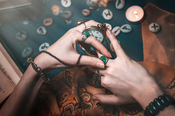 Astrology and esotericism. The female hand of the witch holds a watch in her hands and uses a magic...