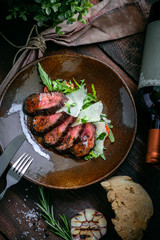 Cooked fillet of beef tenderloin sliced on a plate with an Italian salad. Barbecue dry aged wagyu...