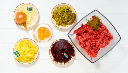Ingredients for a traditional Swedish dish beef Lindstrom. Freshly minced beef, boiled potato, white chopped onion, pickles, pickled red beets, eggs. Swedish cuisine. Scandinavian cuisine.