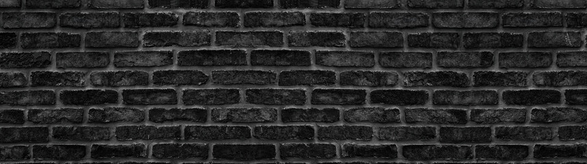 Black brick block large texture. Dark rough masonry widescreen panorama. Gloomy gothic background