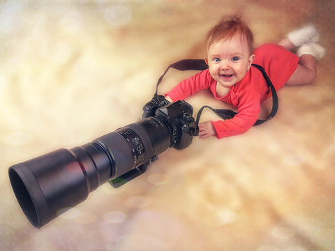 Fototapeta Smiling infant with big telephoto camera lens