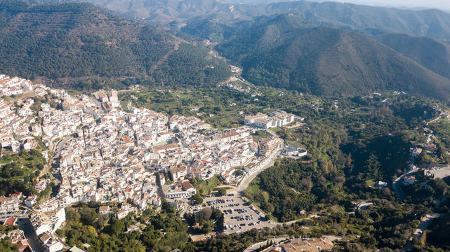 aerial photograph of a town in the south of spain next to marbella, between mountains and green vegetation