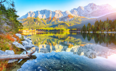 Faboulus autumn landscape of Eibsee Lake in front of Zugspitze summit under sunlight