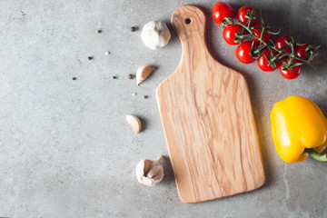 Wooden Cutting Board with Fresh Herbs and Raw Vegetables on Rustic Wood Table. Top view. Cooking...