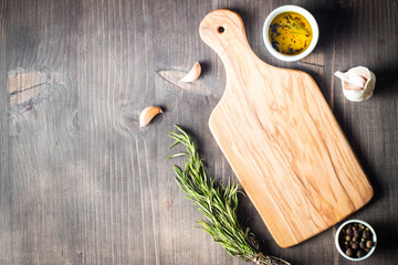 Wooden Cutting Board with Fresh Herbs and Raw Vegetables on Rustic Wood Table. Top view. Cooking...