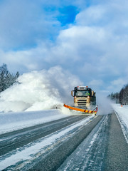 Winter service truck for snow plow clearing road after winter snowstorm.