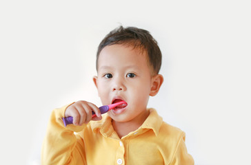 Portrait of little Asian baby boy brushing teeth on on white background.