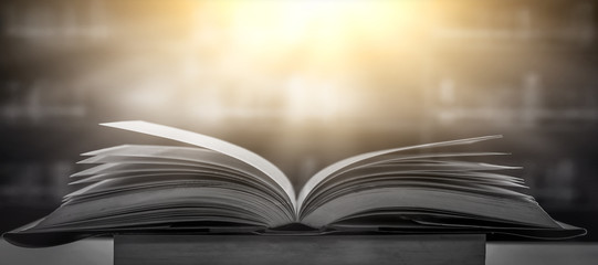 Stack of books in the library and blur bookshelf background	