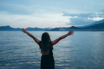 Happy girl rejoices summer. Beautiful, scenic sea landscape. Young child playing outside. Summertime day activity. Happy, joyful kid outdoors. Having fun alone. . Picturesque scenery