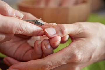 Nail care service at salon, removing cuticle with nail nipper 