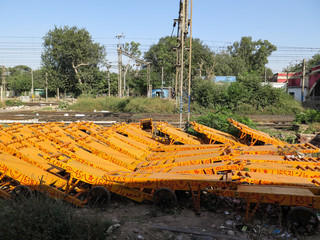 Several Rickshaws on an open space next to a railway in New Delhi, India