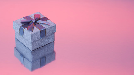 Glitter gift box on pink background with copyspace