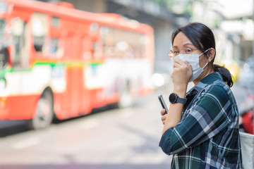 Woman wearing face mask protect filter against air pollution (PM2.5) or wear N95 mask. protect pollution, anti smog and viruses, Air pollution caused health problem. environmental pollution concept.