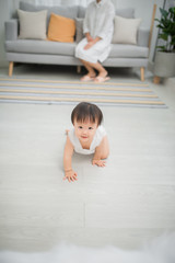 Little girl crawling on the floor in living room