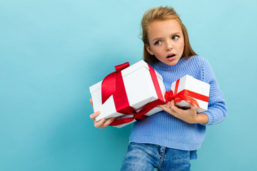 valentine's day concept. charming girl barely holds two gifts on a light blue background