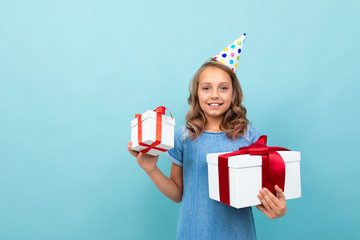girl with a holiday hat holds her gifts on a studio background