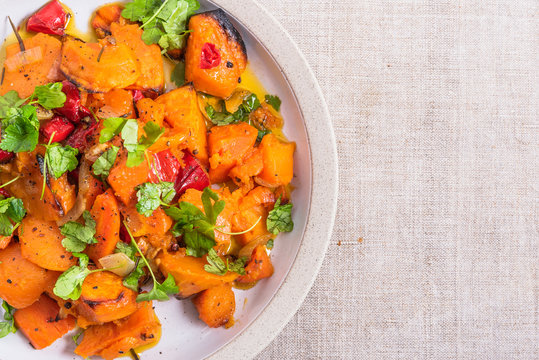 Tasty Vegetarian Dish - Baked Sweet Potato With Onions, Carrots And Basil Leaves In A Plate On The Table, Top View, Copy Space