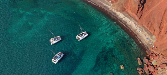 Aerial drone ultra wide photo of famous volcanic red beach in island of Santorini, Cyclades, Greece