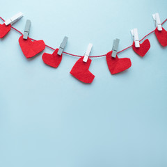 Valentine's day background. Garland of red hearts on a mint blue background.