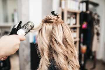 Beautiful hairstyle of woman after dyeing hair and making highlights in hair salon.