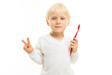 close-up of a handsome blond male child with a toothbrush on a white background showing class