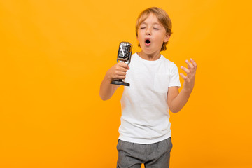 blond boy with a microphone on an orange background