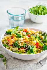 Valentine's Day concept. Salad with pasta hearts, olives, tomatoes, spinach and broccoli in a white bowl.