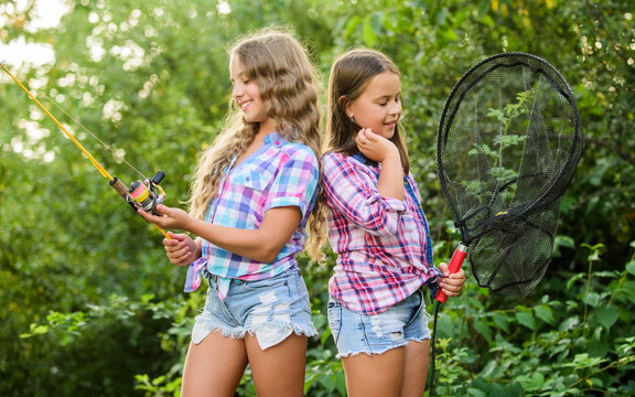 Happy childhood. Adorable girls nature background. Teamwork. Camping activities. Fly fishing. Kids spend time together fishing. Fishing skills. Summer hobby. Happy smiling children with net and rod