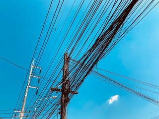 busy electric wire on the street in the city on a background of blue sky