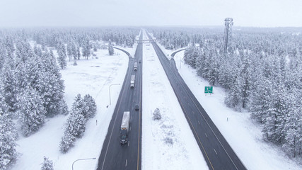 DRONE: Trucks and cars drive along a wet interstate highway during a blizzard.