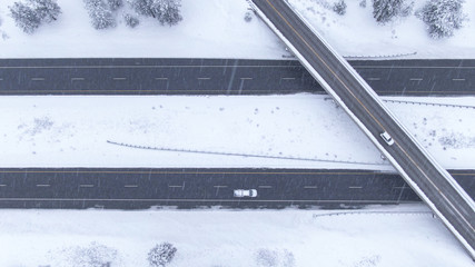 TOP DOWN: Flying over a highway overpass in USA during an intense blizzard.