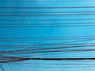 busy electric wire on the street in the city on a background of blue sky