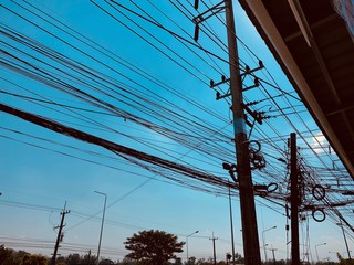 busy electric wire on the street in the city on a background of blue sky