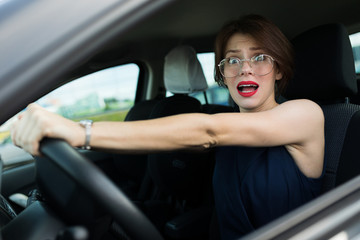Plakat business woman in car on the background of a modern high-rise building