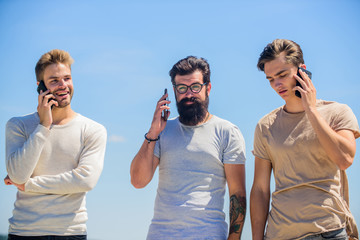 Mobile phone conversation. Friends chatting sky background. Mobile communication. People with...