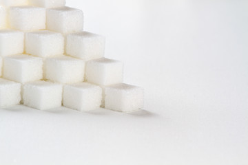 high key closeup of a pyramid of sugar cubes arranged in a cube pattern