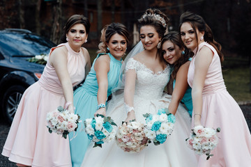 Beautiful bride with her friends. Autumn wedding. Photo of the bride and bridesmaidswith wedding bouquets. Wedding day. Happy girls at their best friend's wedding.