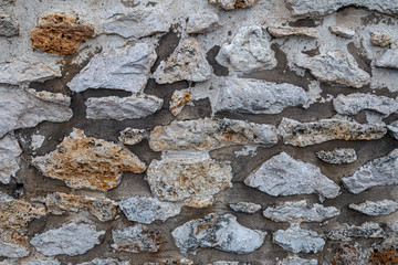 wall of large multicoloured exposed stones in grey cement all around