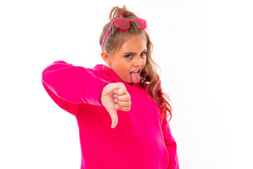 stylish girl in pink clothes gestures with displeasure and shows dislike on a white background