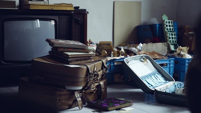 Cold empty abandoned room with retro furniture and wrapped boxes, old retro TV of war times. Abandoned flat room with used trash on the floor, mess in the room, life of war time