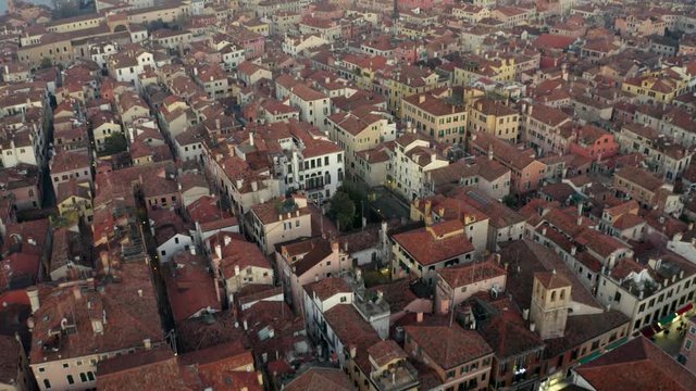 Aerial, tilt, drone shot overlooking buildings and Venetian architecture, at a evening, in Venice, Italy
