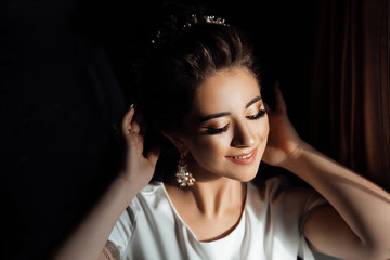 Morning preparations. Wedding. Beautiful bride with makeup and hair style. Bride posing. Bride with her eyes closed shows makeup. Beauty, fashion. Wedding.