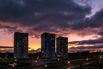 evening fluffy curly rolling clouds of awesome sunset before storm against the background of multi-storey apartment buildings