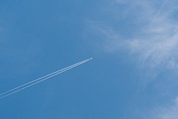 Plane in the sky. Blue background and clouds.