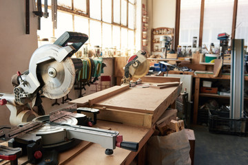 Mitre saws on workbenches in a carpentry workshop - obrazy, fototapety, plakaty